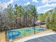 Aerial view of the community basketball court showcasing a modern blue and green design and surrounding trees at 4216 Tattnall Run, Acworth, GA 30101