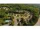 Aerial view of a neighborhood surrounded by lush trees, a community pool and tennis courts at 5015 Preservation Pointe Nw, Kennesaw, GA 30152