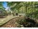 Backyard featuring a peaceful pond with rock landscaping and a backdrop of lush trees and greenery at 5015 Preservation Pointe Nw, Kennesaw, GA 30152