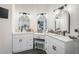 Bathroom featuring dual vanities with white cabinetry, modern lighting, and marble countertops at 5015 Preservation Pointe Nw, Kennesaw, GA 30152