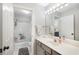 Bright bathroom features a shower-tub combo, white tiled walls, and a vanity with a large mirror and modern lighting at 5015 Preservation Pointe Nw, Kennesaw, GA 30152