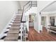 Bright entryway with hardwood floors, staircase, and view into the living room featuring a stone fireplace at 5015 Preservation Pointe Nw, Kennesaw, GA 30152