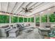Relaxing sunroom filled with natural light boasts comfortable seating, ceiling fan, and views of the surrounding lush greenery at 5015 Preservation Pointe Nw, Kennesaw, GA 30152