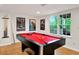 Basement rec room with a red pool table set beneath recessed lights and a well lit window with cue sticks at the ready at 4140 Summit Dr, Marietta, GA 30068