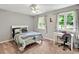 Bright bedroom with soft gray walls, two windows, and a cozy desk area, creating a comfortable and inviting space at 4140 Summit Dr, Marietta, GA 30068