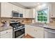 Well-equipped kitchen with stainless steel gas range, microwave, and ample counter space at 4140 Summit Dr, Marietta, GA 30068