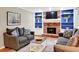 Comfortable living room featuring a brick fireplace, built-in bookshelves and cozy grey couches at 4140 Summit Dr, Marietta, GA 30068