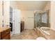 This bathroom features a luxurious soaking tub next to a glass-enclosed shower, along with vanity and decorative tile at 5888 Cobblestone Creek Cir, Mableton, GA 30126