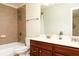Bathroom featuring double sinks, a large mirror, and a bathtub with tile surround at 5888 Cobblestone Creek Cir, Mableton, GA 30126
