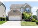 Charming two-story home featuring a brick and stone facade, a two-car garage, and a well-maintained lawn at 5888 Cobblestone Creek Cir, Mableton, GA 30126