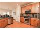 Functional kitchen featuring stainless steel appliances, wood cabinets, granite countertops, and wood floors at 5888 Cobblestone Creek Cir, Mableton, GA 30126