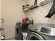 Bright laundry room with washer, dryer, and storage shelves at 5888 Cobblestone Creek Cir, Mableton, GA 30126