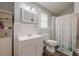 The clean bathroom has a white vanity, mirror, toilet, and a shower with a decorative curtain at 2497 Edwards Nw Dr, Atlanta, GA 30318