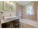 Well-lit bathroom showcasing a dark vanity, vessel sink, jetted tub, and soft, neutral wall tones at 2497 Edwards Nw Dr, Atlanta, GA 30318