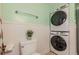 A cozy bathroom features a toilet next to the stacked washer/dryer set at 2497 Edwards Nw Dr, Atlanta, GA 30318