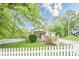 Inviting home featuring a well-manicured lawn, mature trees, and a classic white picket fence at 2497 Edwards Nw Dr, Atlanta, GA 30318