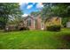 Backyard with lush green lawn and mature trees, showing exterior of home at 4896 Muirwood Dr, Powder Springs, GA 30127