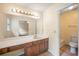 Bathroom with vanity and large mirror, toilet, and tub with shower at 4896 Muirwood Dr, Powder Springs, GA 30127