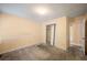 Carpeted bedroom with neutral color scheme, closet with bi-fold doors, and access to other rooms at 4896 Muirwood Dr, Powder Springs, GA 30127