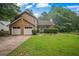 Well-maintained two-story home with attached garage, landscaped front yard, and welcoming entrance at 4896 Muirwood Dr, Powder Springs, GA 30127