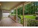 Inviting front porch with wood floors and railing overlooking a well-manicured front yard at 4896 Muirwood Dr, Powder Springs, GA 30127