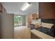 Functional kitchen with wood cabinets, tile floors, and an adjacent breakfast nook at 4896 Muirwood Dr, Powder Springs, GA 30127