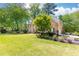 Landscaped front yard with beautiful brick home, mature trees, and manicured garden beds at 93 Ridgetree Ln, Marietta, GA 30068
