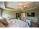 Spacious bedroom with tray ceiling, a wall-mounted TV, and comfortable seating at 13568 Scenic Pkwy, Covington, GA 30014
