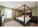 Bedroom featuring a wooden framed bed and a window with sheer curtains at 13568 Scenic Pkwy, Covington, GA 30014