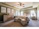 Bright bedroom featuring neutral tones, tray ceiling, comfortable seating, dresser, and a ceiling fan at 13568 Scenic Pkwy, Covington, GA 30014