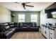 Comfortable bonus room with a leather sofa, ceiling fan, and TV at 13568 Scenic Pkwy, Covington, GA 30014