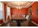 Formal dining room featuring a modern chandelier, seating for eight, and an orange accent wall at 13568 Scenic Pkwy, Covington, GA 30014