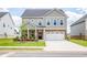 Charming two-story home features brick and gray siding, a two-car garage, and a well-manicured lawn at 13568 Scenic Pkwy, Covington, GA 30014