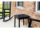 Cozy porch with rocking chairs and a side table next to a brick exterior and window at 13568 Scenic Pkwy, Covington, GA 30014