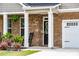 Inviting front porch with brick columns and black rocking chairs, creating a cozy outdoor space at 13568 Scenic Pkwy, Covington, GA 30014