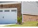 Attached two-car garage with classic white door and brick detailing at 13568 Scenic Pkwy, Covington, GA 30014