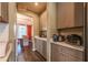 Hallway view looking into dining room, grey cabinets, quartz countertops, and stainless steel appliances at 13568 Scenic Pkwy, Covington, GA 30014
