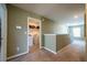Hallway with neutral carpet and view to the laundry room at 13568 Scenic Pkwy, Covington, GA 30014