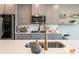 Close up shot of kitchen featuring gray cabinets, brass hardware, quartz countertops, and stainless appliances at 13568 Scenic Pkwy, Covington, GA 30014