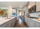 Open kitchen view features an island, stainless steel appliances, and gray cabinets with brass hardware at 13568 Scenic Pkwy, Covington, GA 30014