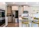 Bright kitchen featuring gray cabinets with gold hardware, stainless steel appliances, and quartz countertops at 13568 Scenic Pkwy, Covington, GA 30014