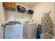 Bright laundry room with washer, dryer, shelving, and ironing board, perfect for convenience at 13568 Scenic Pkwy, Covington, GA 30014