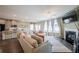 Bright living room with fireplace, large windows, and an open layout leading into the kitchen and dining areas at 13568 Scenic Pkwy, Covington, GA 30014