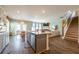 Open-concept living area featuring an island kitchen, dining area, stairs and comfortable seating at 13568 Scenic Pkwy, Covington, GA 30014
