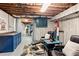 Finished basement with gray floors, leather chairs, and blue accent cabinets at 211 Caboose Ln, Woodstock, GA 30189