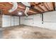 Unfinished basement with exposed ceiling, cement walls, and garage door at 211 Caboose Ln, Woodstock, GA 30189