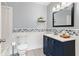 Bathroom with blue vanity, white walls, patterned tile accent, and vinyl flooring at 211 Caboose Ln, Woodstock, GA 30189