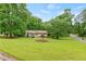 Beautifully landscaped front yard with mature trees surrounding a cozy home with a well-maintained lawn at 211 Caboose Ln, Woodstock, GA 30189