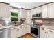 Updated kitchen features stainless steel appliances and stylish backsplash at 211 Caboose Ln, Woodstock, GA 30189