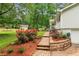 Beautifully landscaped yard with brick walkway, vibrant rose bushes, and mature trees at 211 Caboose Ln, Woodstock, GA 30189